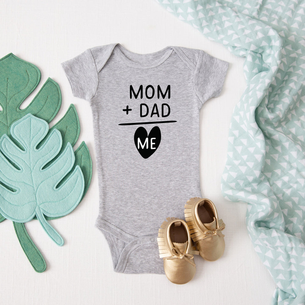 Mom + Dad = Me baby bodysuit lifestyle photo - gray bodysuit laid flat on a leaf-print background