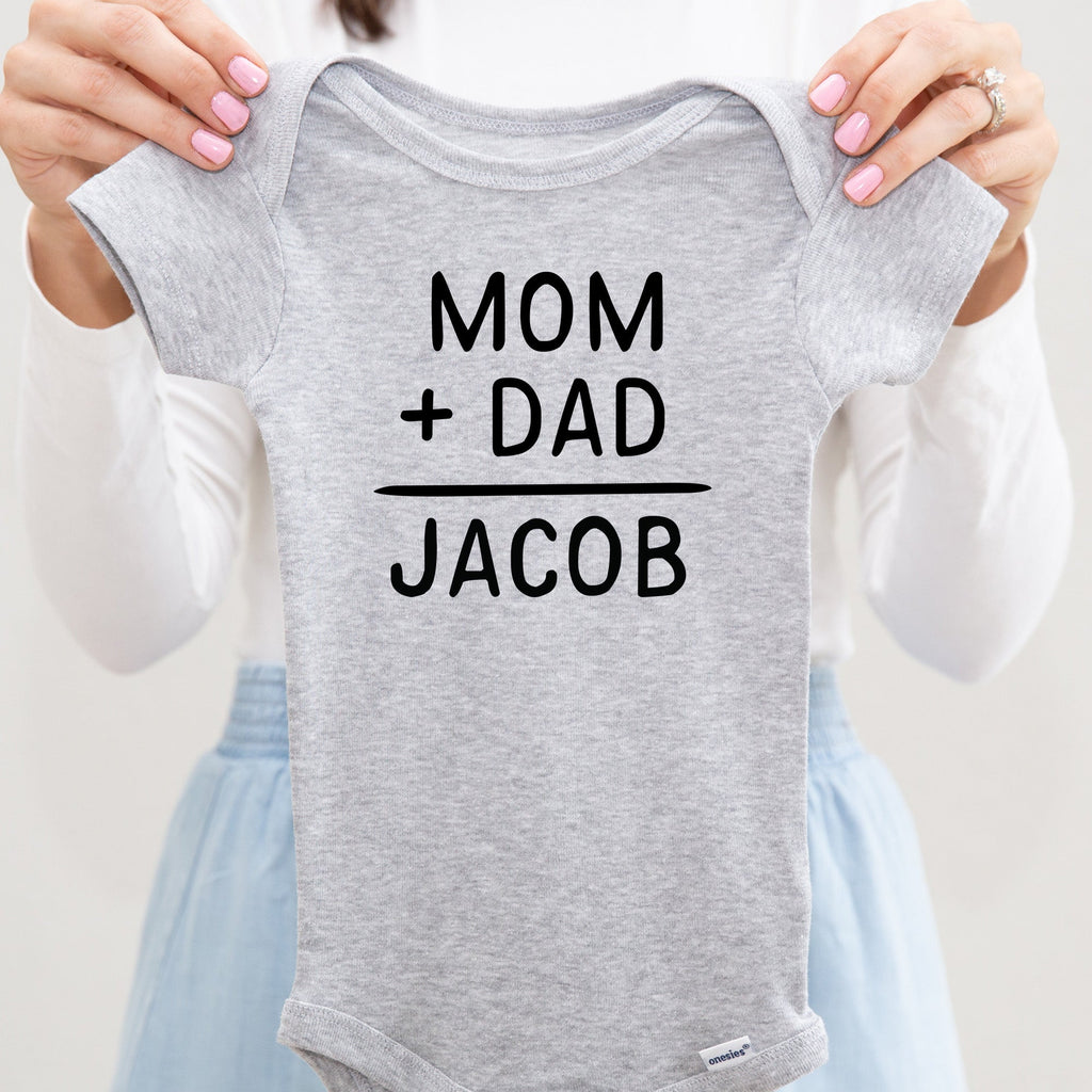 Mom + Dad = Baby Name personalized baby bodysuit lifestyle photo - gray bodysuit being held by an adult