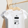 Battery: Me and Parents baby bodysuit lifestyle photo - white bodysuit hanging on a wooden hanger, close-up