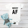 Needy AF baby bodysuit lifestyle photo - white bodysuit displayed near elephant nursery decor