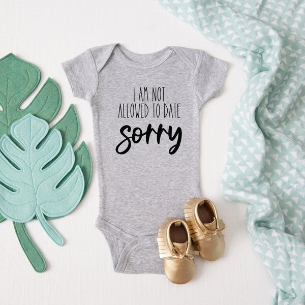 I'm Not Allowed to Date, Sorry baby bodysuit lifestyle photo - gray bodysuit laid flat on a leaf-print background