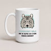 A white ceramic mug with a printed graphic of a wolf's face on a light blue circular background, above Polish text reading 'PRAWDZIWY WILK MA W DUPIE CO O NIM SĄDZA BARANY'. The mug is photographed against a plain, warm off-white background.