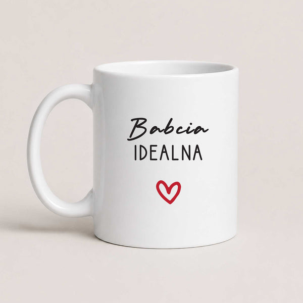 A White 11oz ceramic Polish coffee mug featuring the 'Babcia Idealna' design with a delicate heart accent