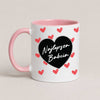 A Pink 11oz ceramic Polish coffee mug featuring the 'Najlepsza Babcia' design with a bold black heart and red heart pattern